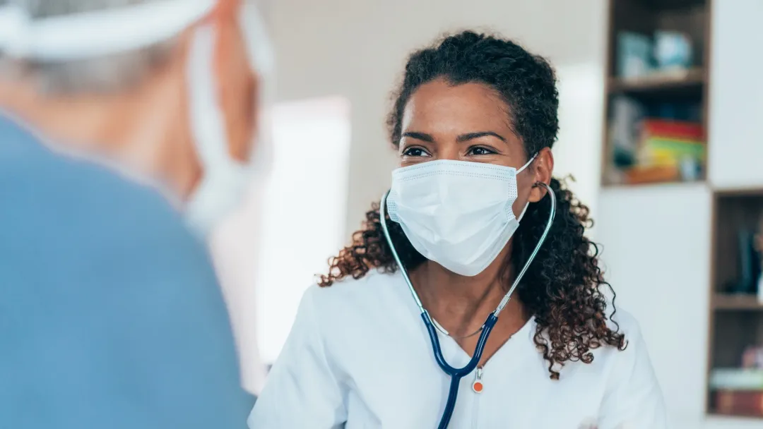 Doctors talking with each other while wearing masks.