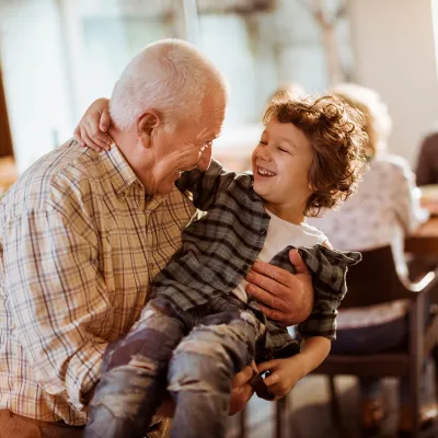 A grandfather holding his grandson on his lap.