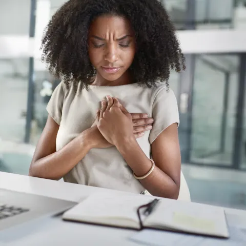 A young woman experiencing chest pain.