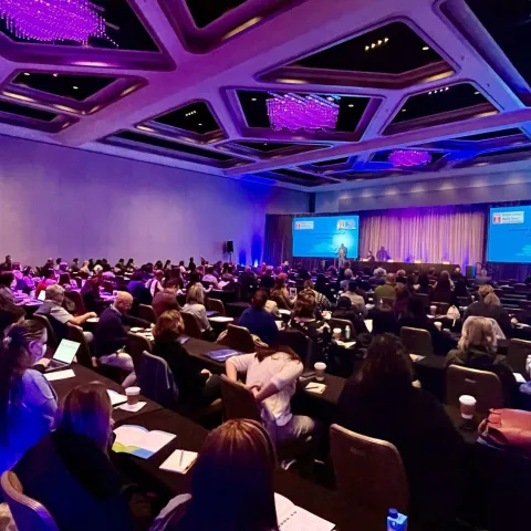 A room full of people attending a presentation.
