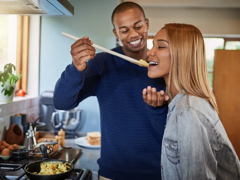 A couple taste tests their meal before eating.