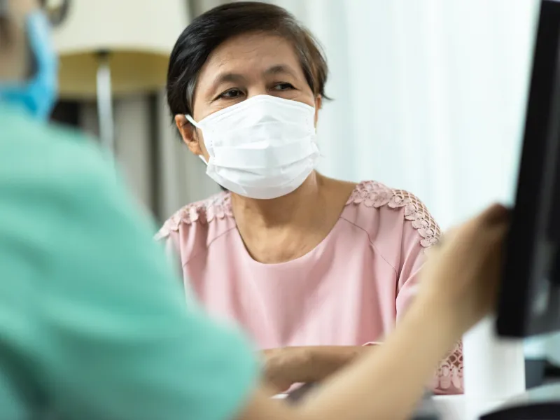 A woman at a doctor's appointment wearing a mask.