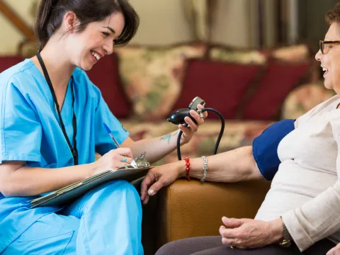 Woman having blood pressure screened