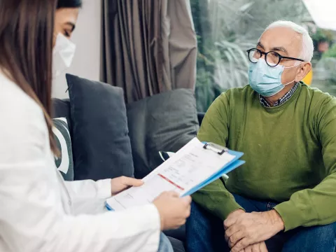 A senior gentleman sitting with his doctor